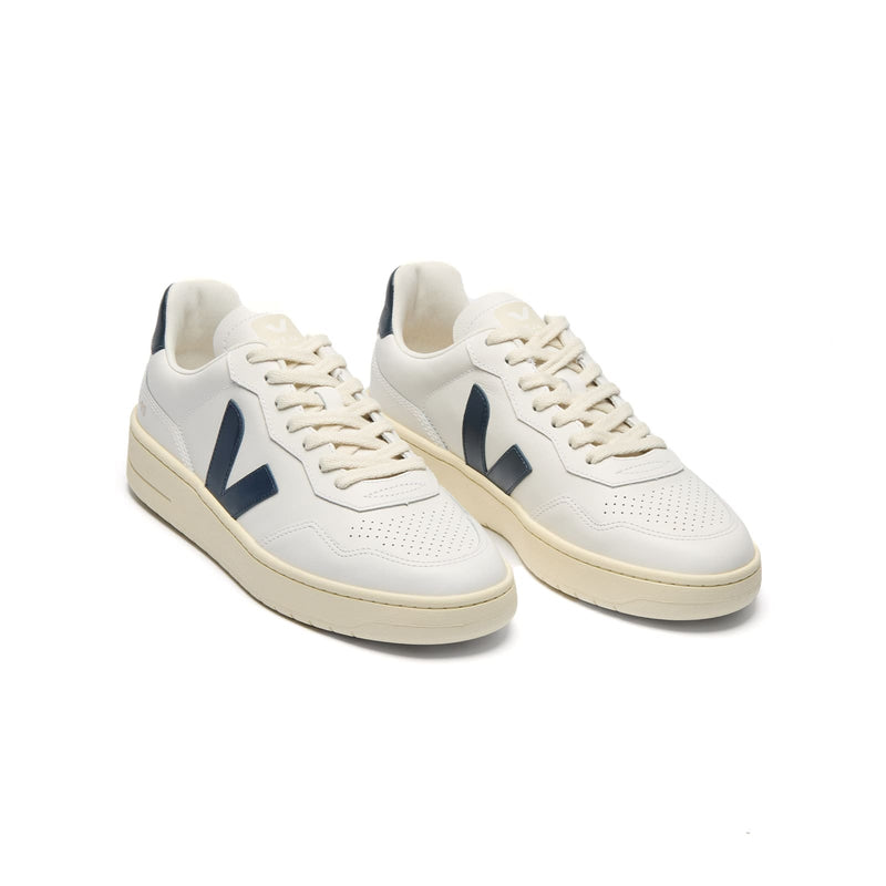 3/4 view of VEJA V-90 leather sneakers in white with blue logo accents